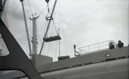 Платформа, подвешенная к крану, для разгрузки ящиков с рыбой в трюме рефрижераторного судна. 1986
